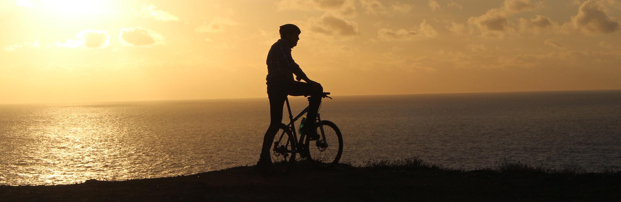 silhouette of a cyclist at sunset
